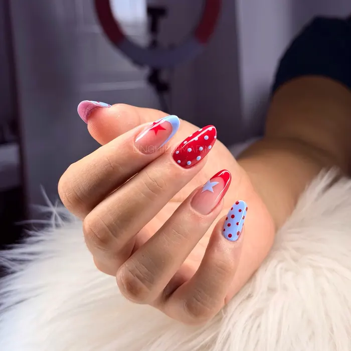 Nail art a pois rossi e blu su fondo chiaro
