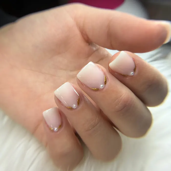 Unghie nude con perline applicate alla base